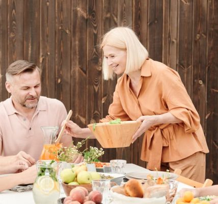 A joyful family gathering outdoors enjoying a meal together with laughter and connection.
